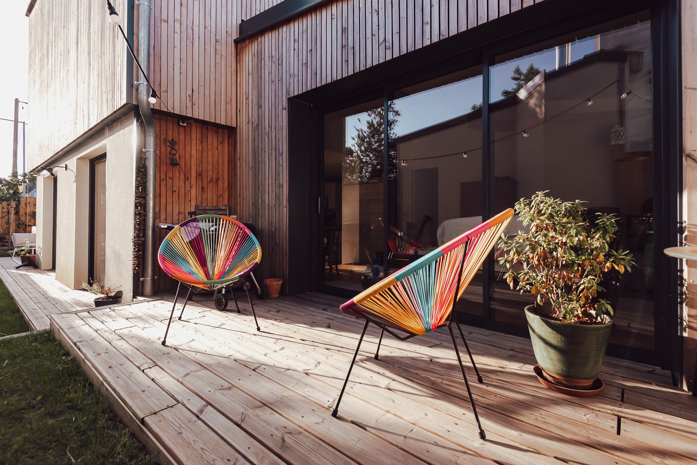 salon-exterieur-chaises-de-couleur-sur-terrasse-en-bois