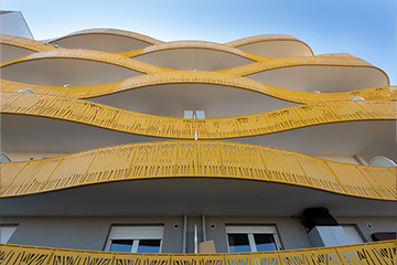 facade d'un immeuble avec des balcons jaunes qui forment des vagues